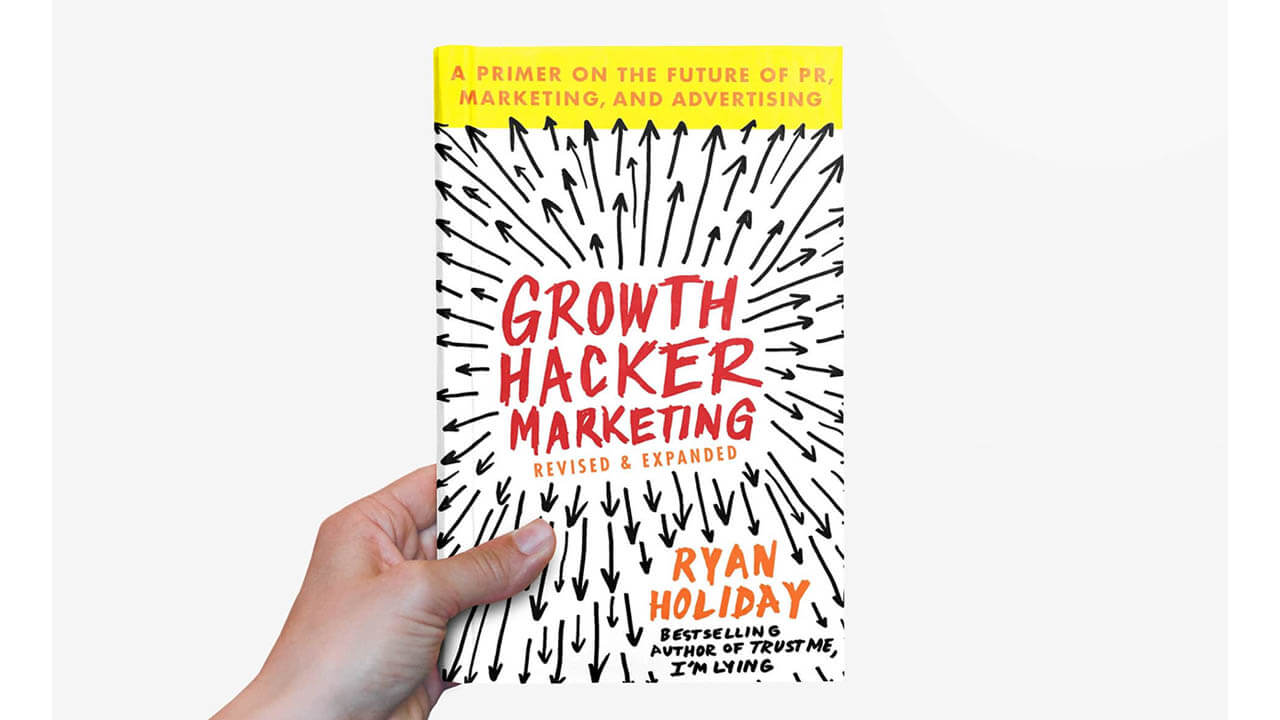 Image of a hand holding a copy of Growth Hacker Marketing