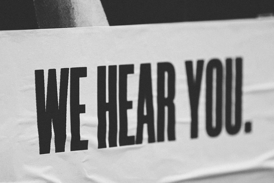 black and white bold letters on poster saying we hear you